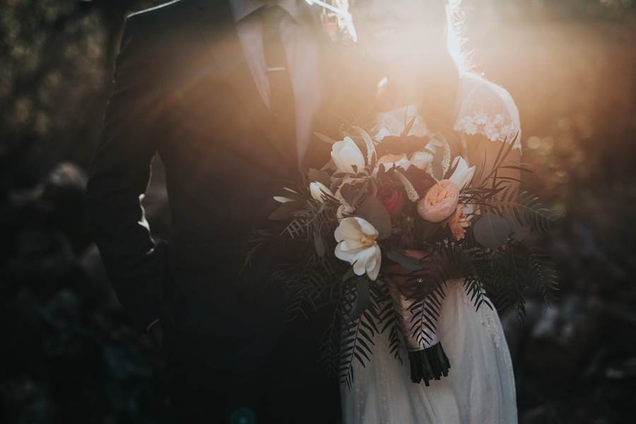 Couple with bouquet at golden hour
